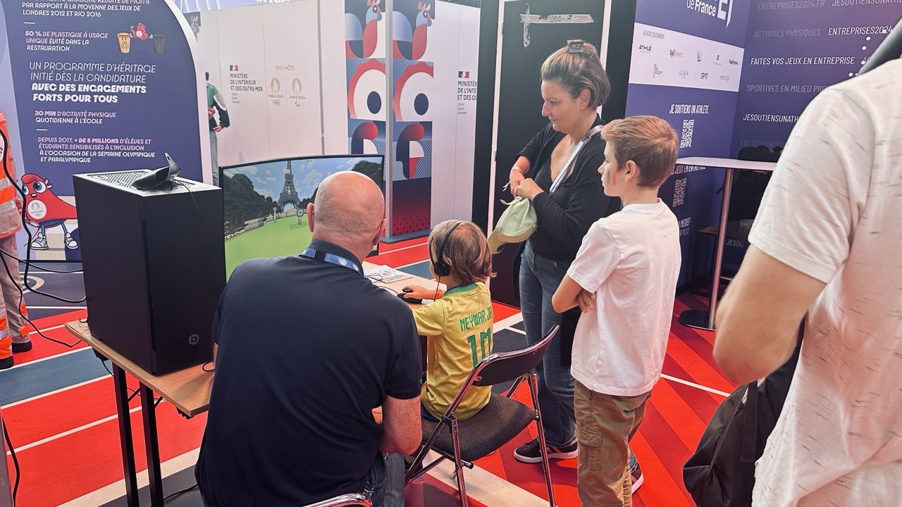 Le stand Medef Sport, un visiteur joue devant la Tour Eiffel cubique